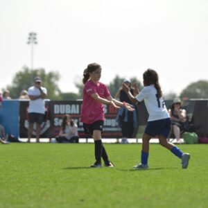 Meiden geven highfive tijdens het voetballen