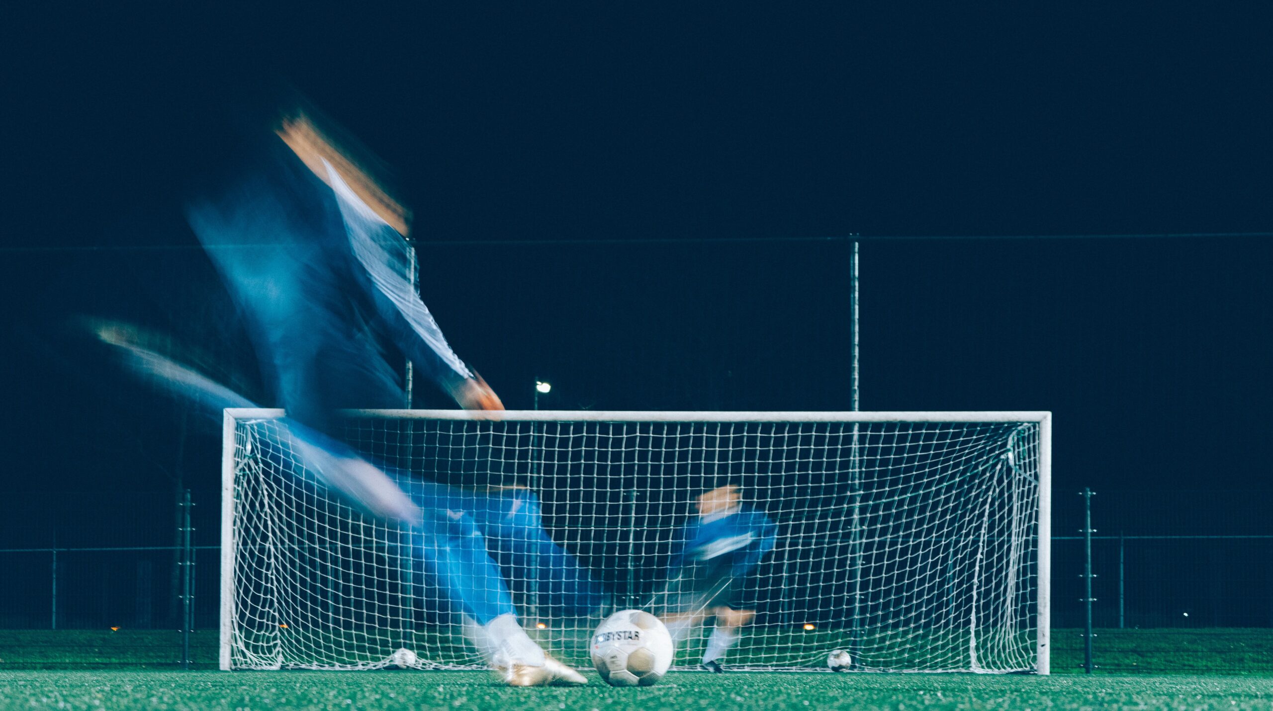 Voetballers spelen veldvoetbal in het donker bij kunstlicht door vind je team